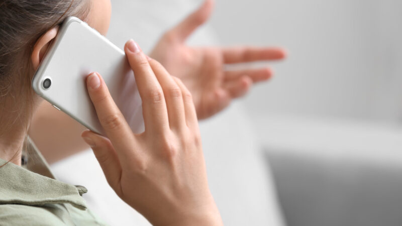 Woman talking by mobile phone at home