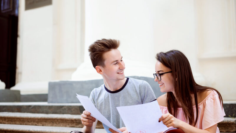 Happy university students share results of final test. Both have received the highest mark for their examination
