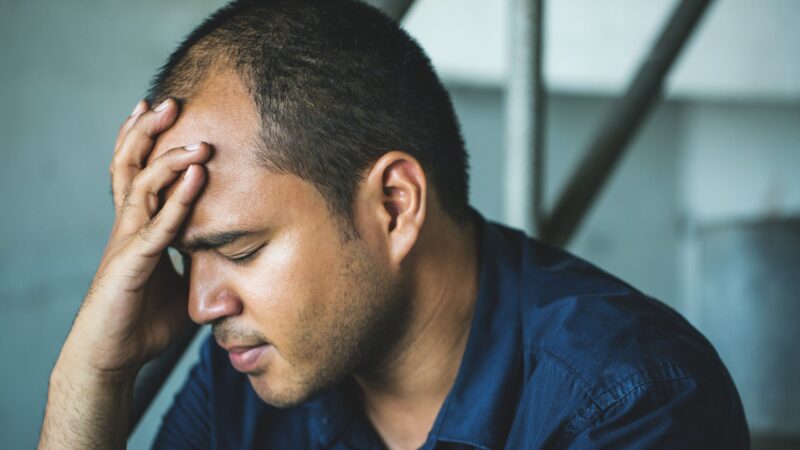 depressed man sitting in dark room