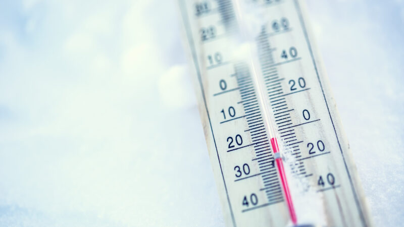 Thermometer on snow shows low temperatures under zero. Low temperatures in degrees Celsius and fahrenheit. Cold winter weather twenty under zero.