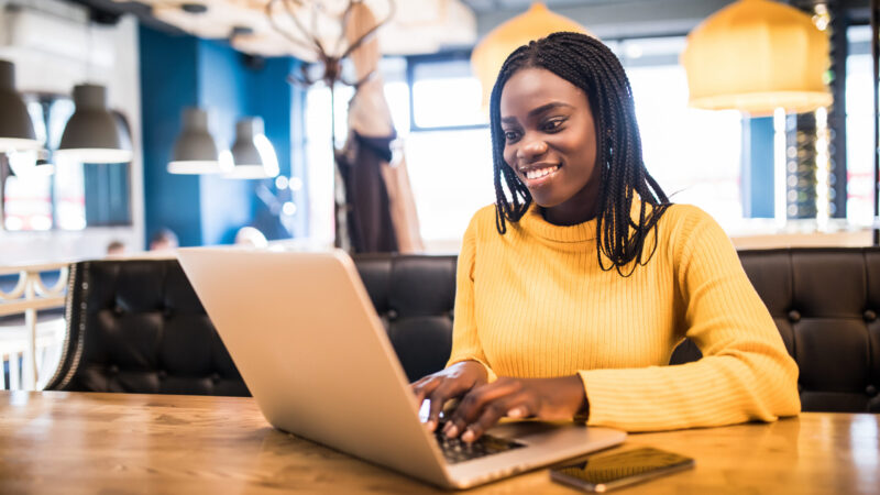 African american business woman with laptop in a cafe