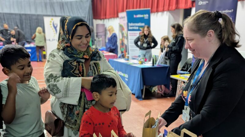 Visitor Fatiha Begum and her two children speaking to a NHS Mid and South Essex staff member