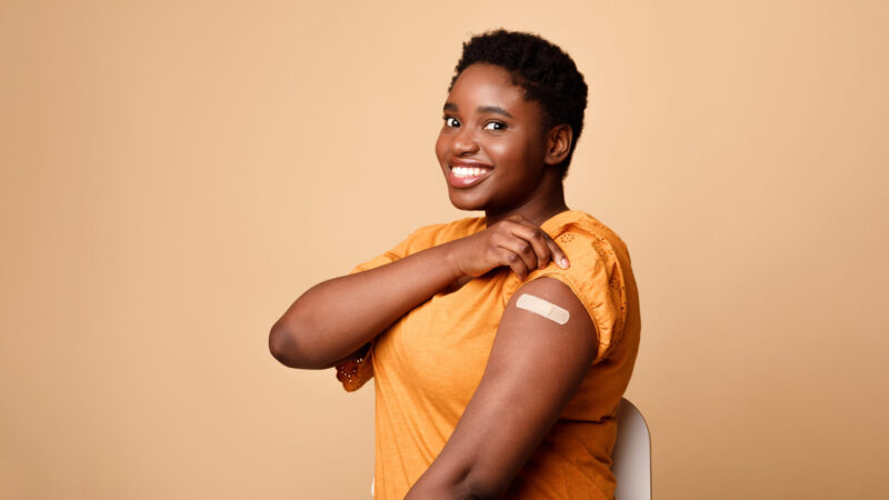 Black,Woman,Showing,Vaccinated,Arm,After,Vaccine,Injection,,Beige,Background