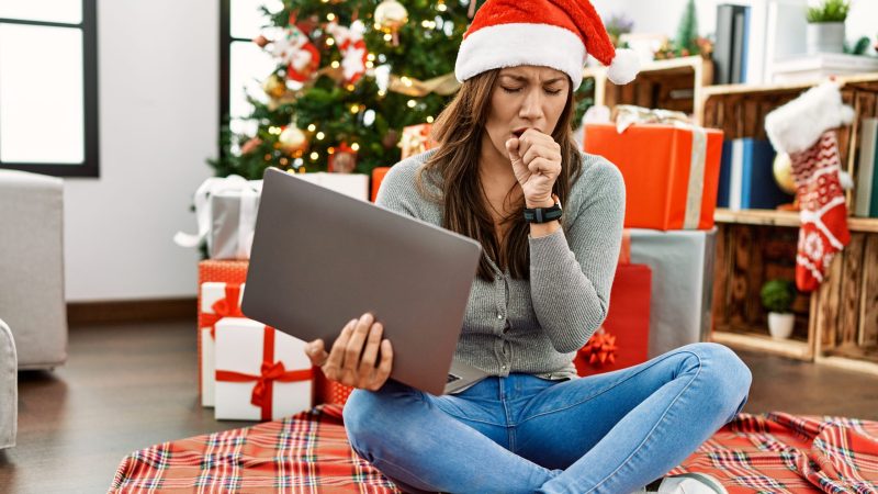 Young,Latin,Woman,Using,Laptop,Sitting,By,Christmas,Tree,Feeling